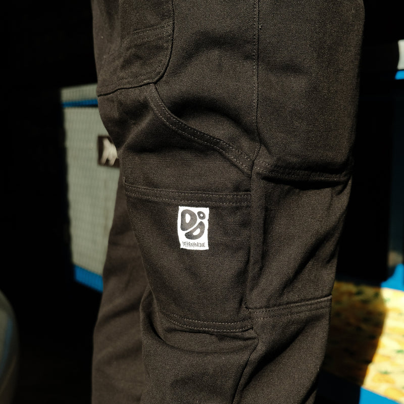 Close-up of black trousers with a Destroy or Die logo on a blurred background