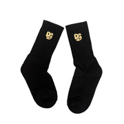 Black socks with gold logos on a textured surface