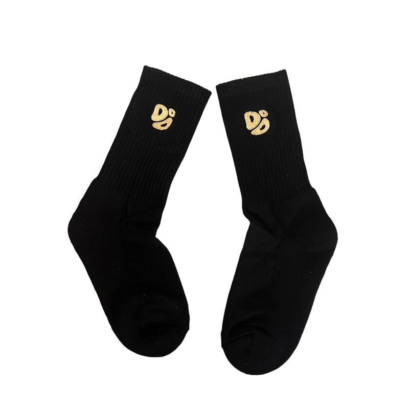 Black socks with gold logos on a textured surface