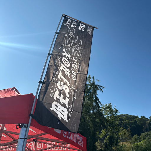 A tall black vertical banner flag with white stylized text and flame graphics of each Destroy or Die logo